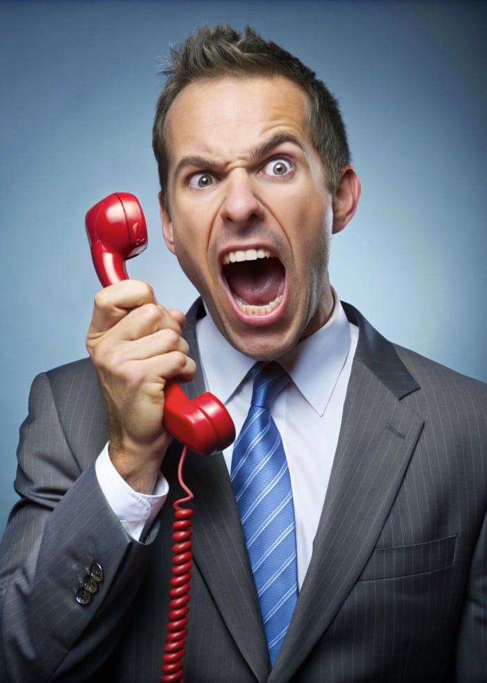 https://www.focus-on.gr/wp-content/uploads/2025/04/angry-businessman-shouting-into-red-vintage-phone-office-setting-seo-optimized-image-website.jpg